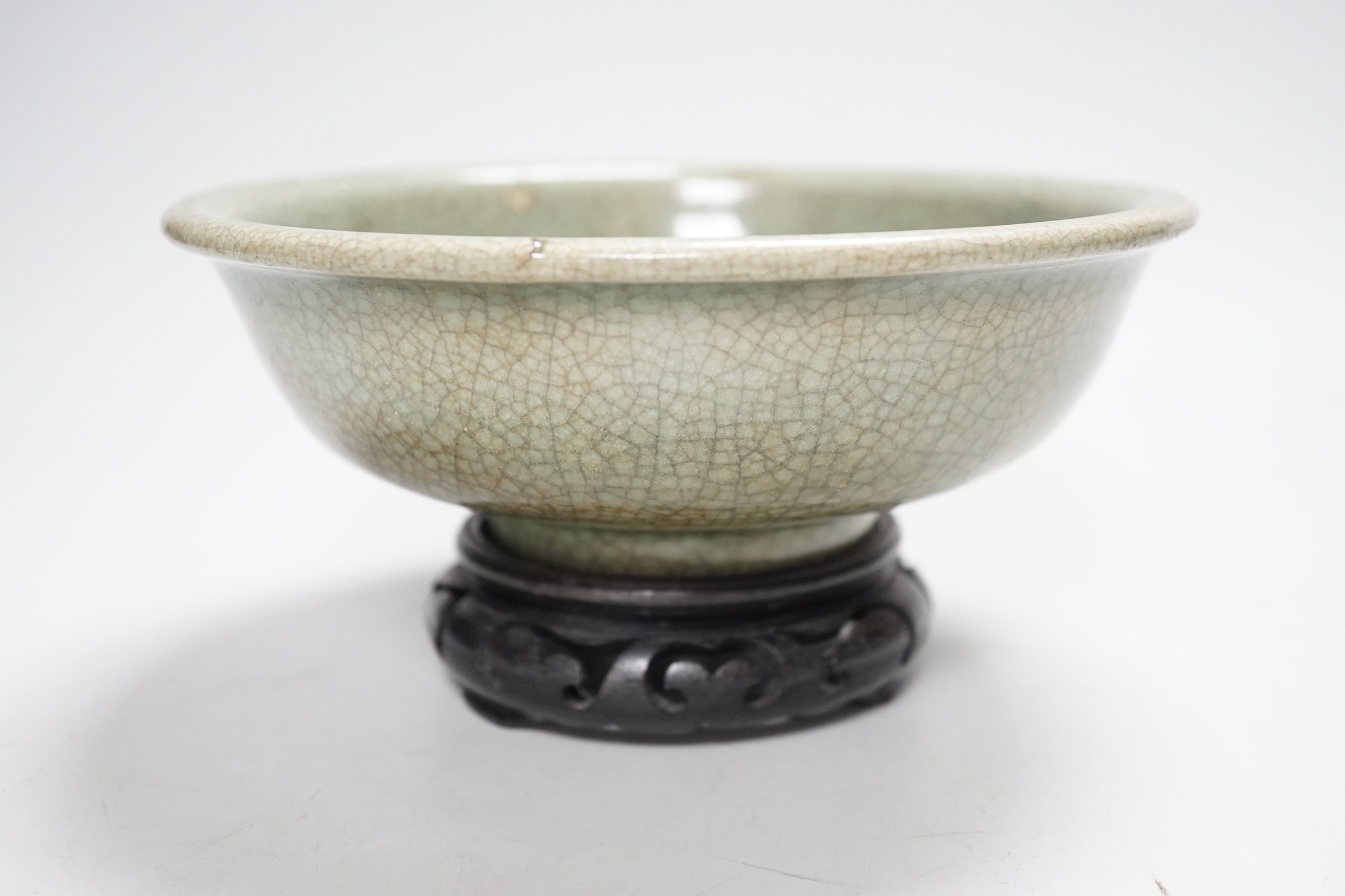 A Chinese Guan type green crackle glaze bowl, early 20th century 19cm diameter, on hardwood stand